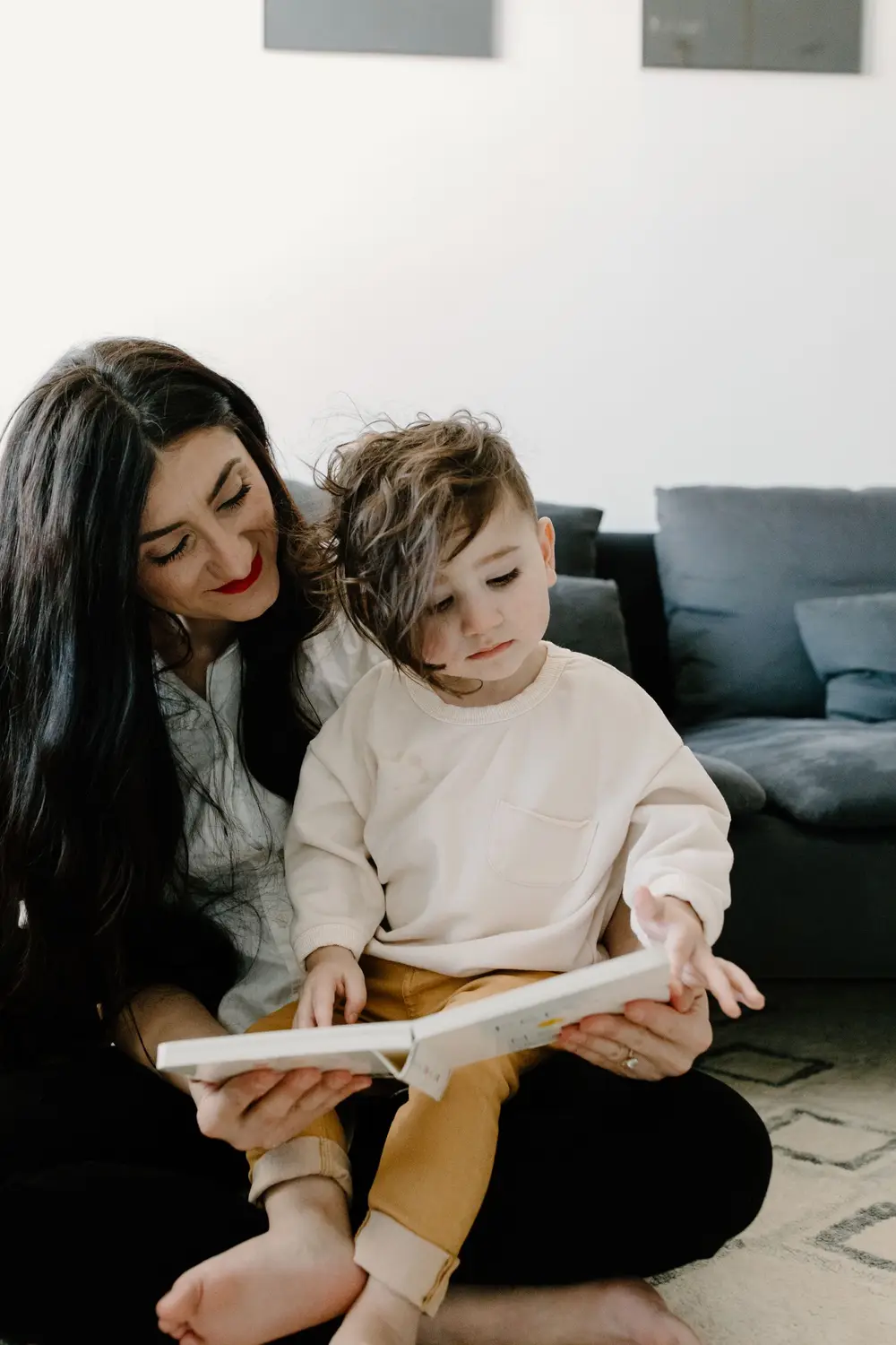 Mamá y su hijo aprendiendo juntos con un libro en casa