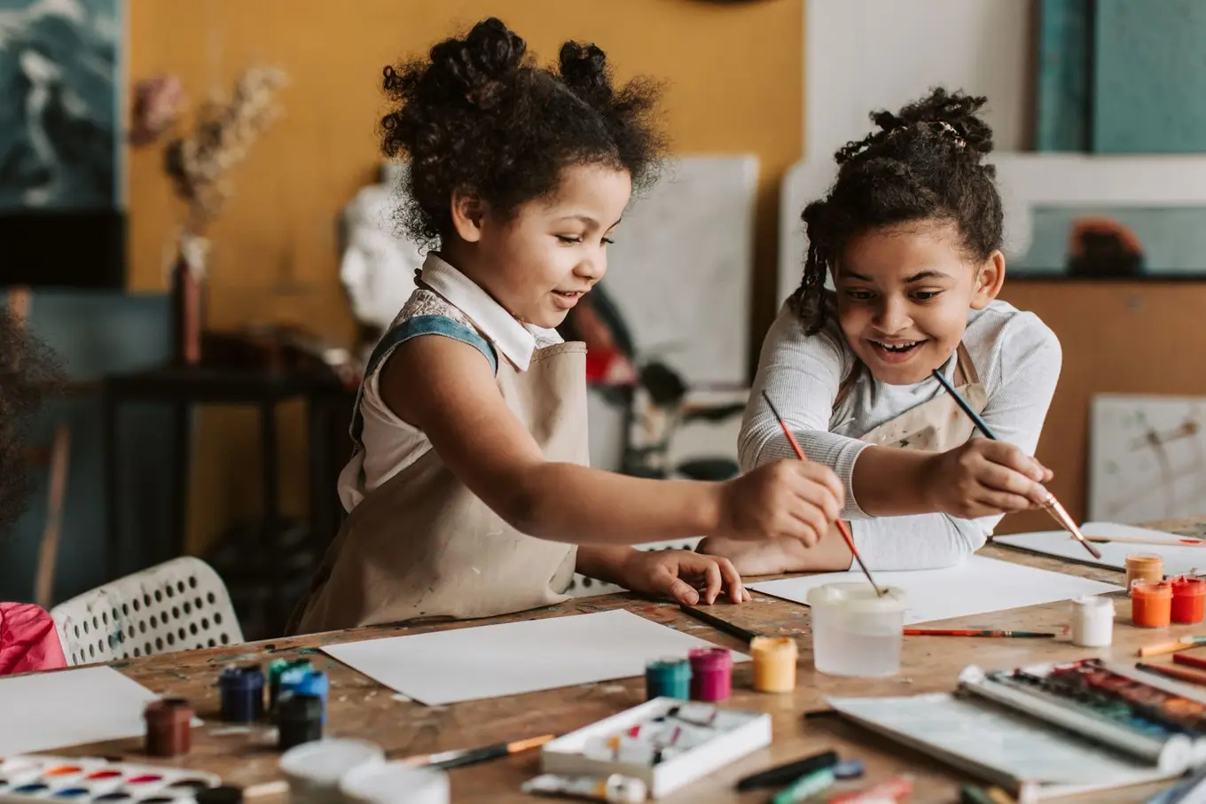 Dos niñas pintando con materiales de arte