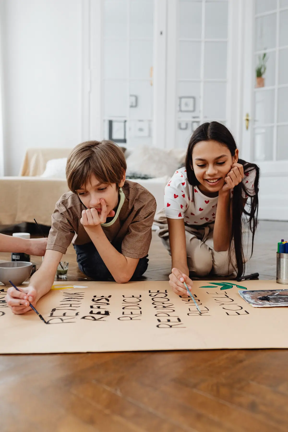 Niña aprendiendo las letras en el suelo junto a su mamá