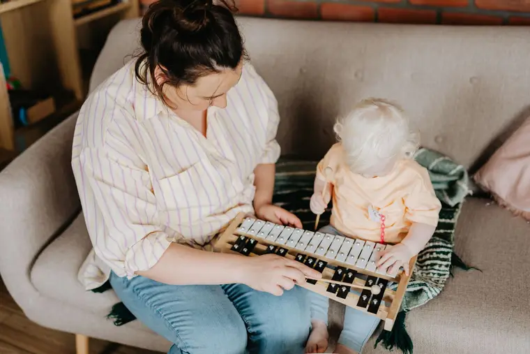 Mamá y su hija tocando un xilófono en casa